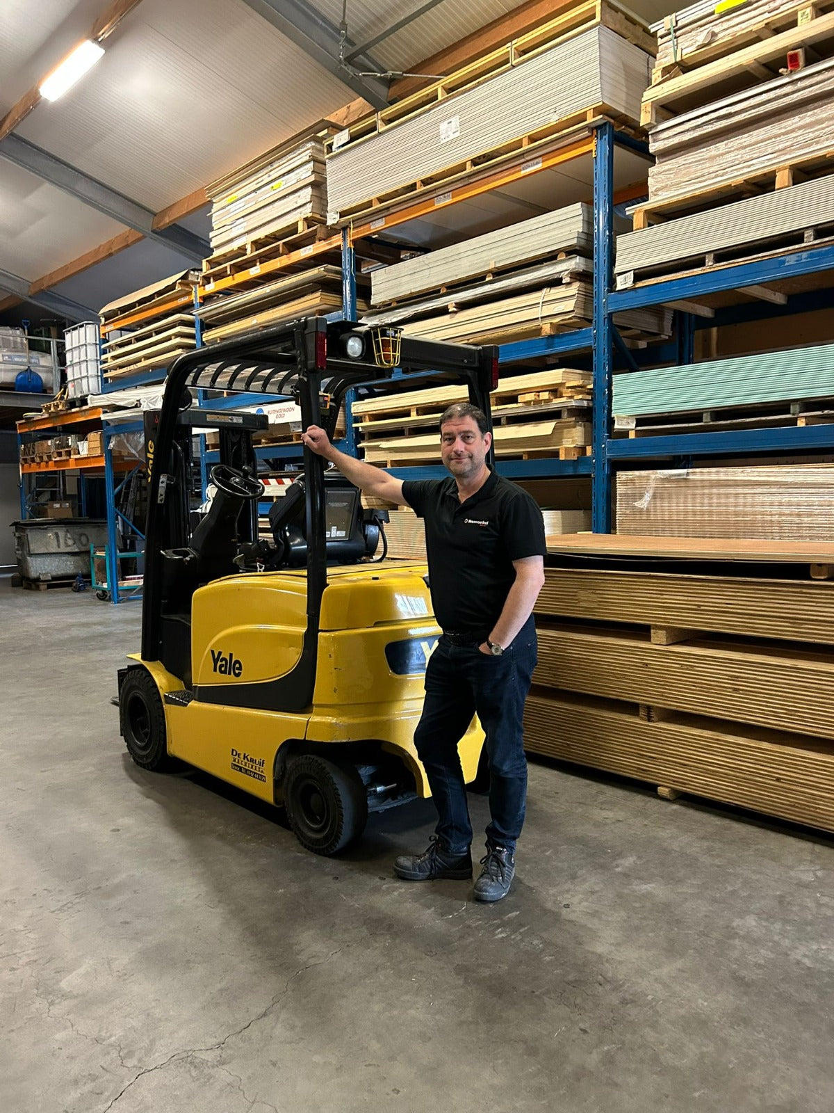 Leo van der Kolk bij de heftruck in het magazijn van Bouwvoordeel Barneveld